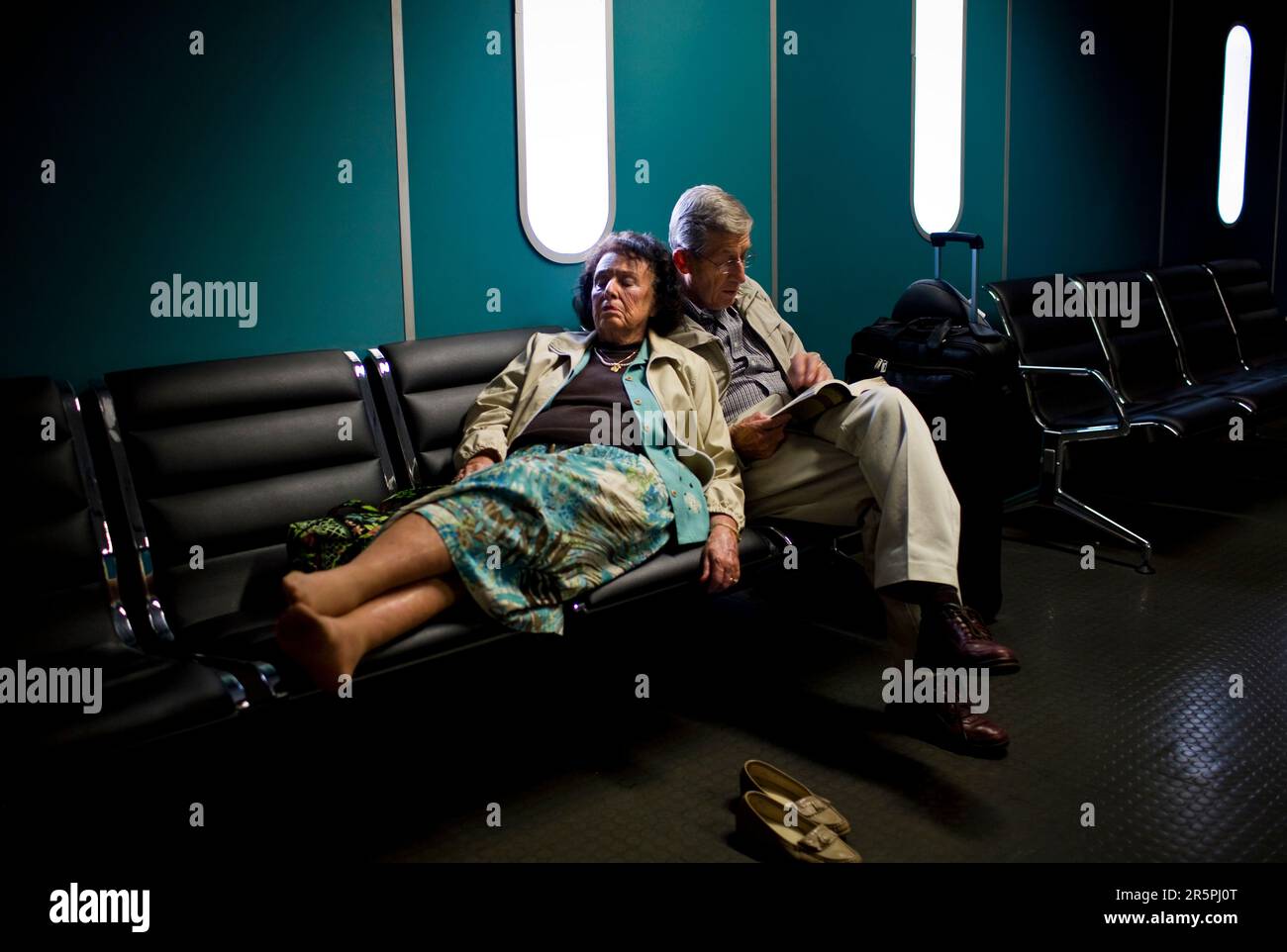 A travel weary couple rests as they await their flight to Livingstone, Zambia at OR Tambo International Airport in Johannesburg, South Africa, October 30, 2007. Stock Photo