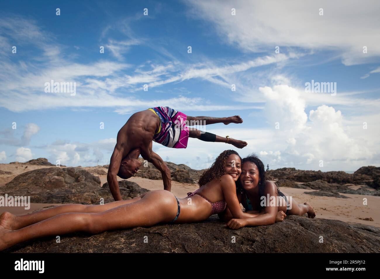 A capoeirista does an inversion on Itapua beach with some