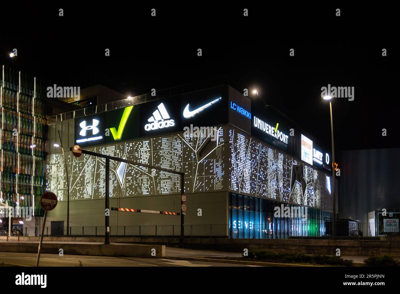 06.01.2023, Novi Sad, Serbia. Night city and facade of shopping mall with  glowing logos of brands Adidas, Lcwaikiki, Nike and others. Business and  adv Stock Photo - Alamy