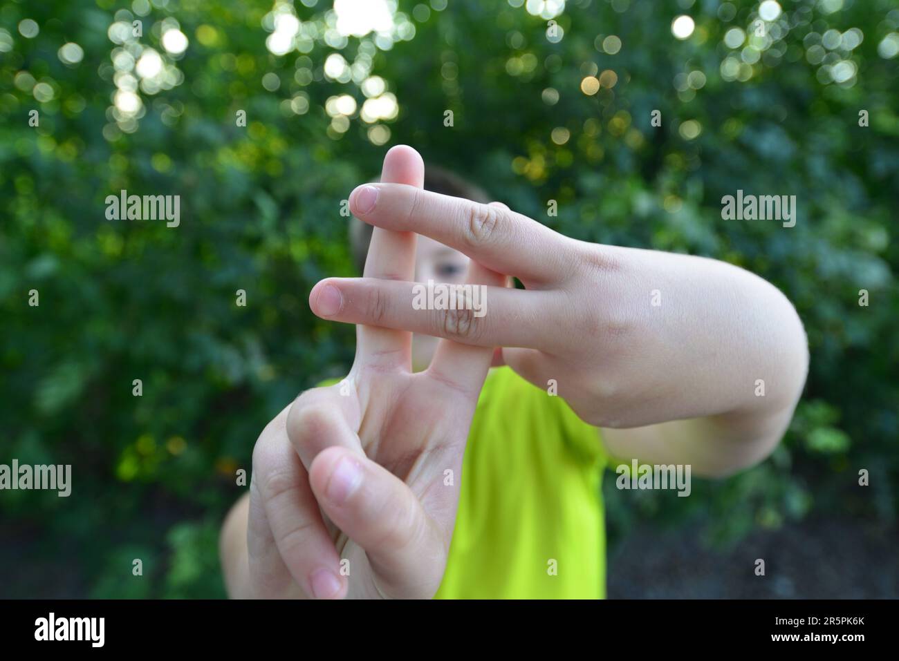 A Boy shows sign gesture prison bars Stock Photo - Alamy