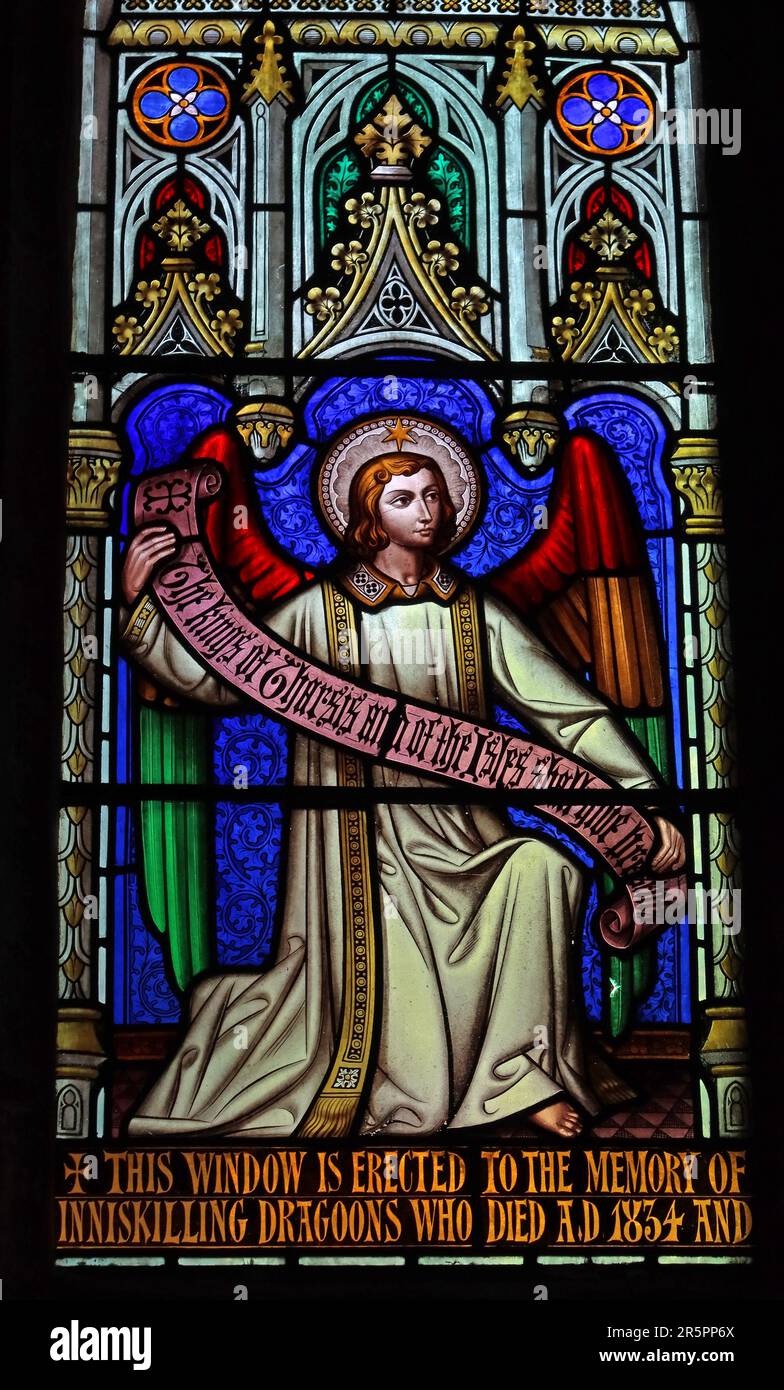 Stained glass memorial window commemorating the Inniskilling Dragoons who died in 1854, featuring an angel figure and Victorian military inscription Stock Photo