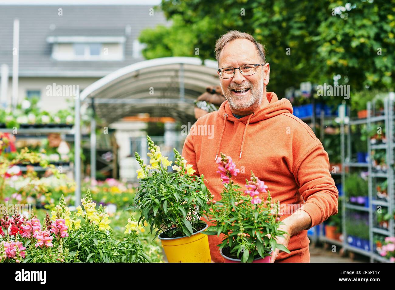 Man in garden holding plants hi-res stock photography and images - Alamy