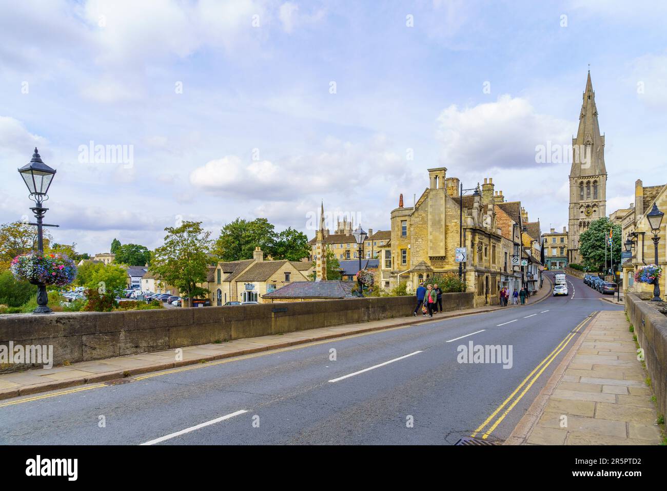 Stamford, UK - September 22, 2022: View of the Stamford bridge over the Welland River, and the Saint Mary church, with locals and visitors, in Stamfor Stock Photo