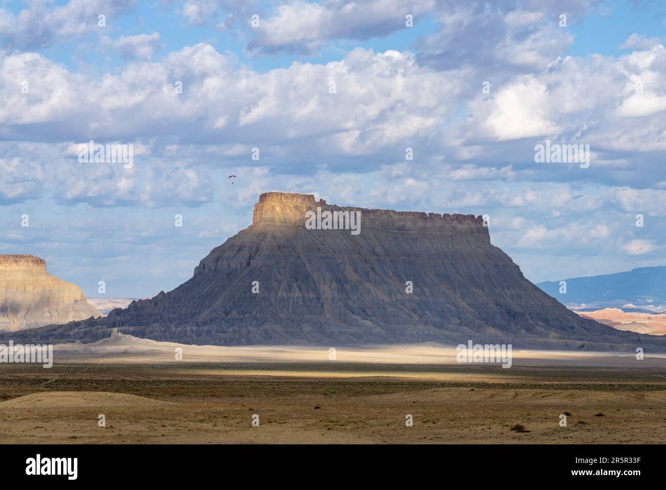 A paramotor flying near the summit of Factory Butte in the Caineville Desert near Hanksville, Utah. Stock Photo