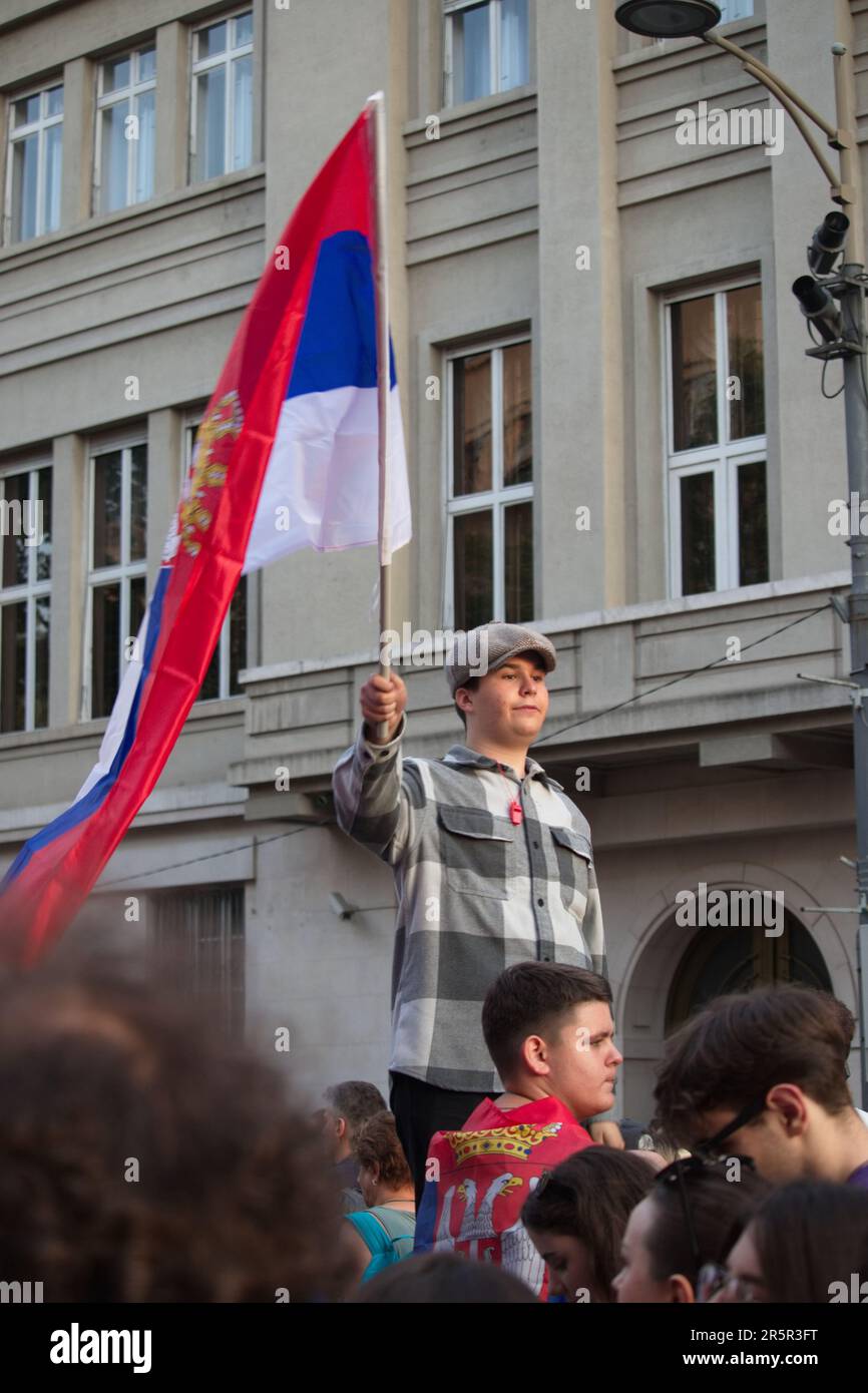 A boy waving a Serbian flag at a protest in Belgrade where the gathered citizens express their disagreement with the current government's policy. Stock Photo
