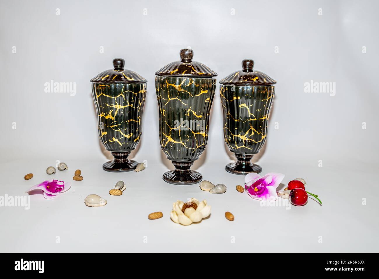 The Set of Three Black Ceramic Jars with Gold Motifs is a stunning