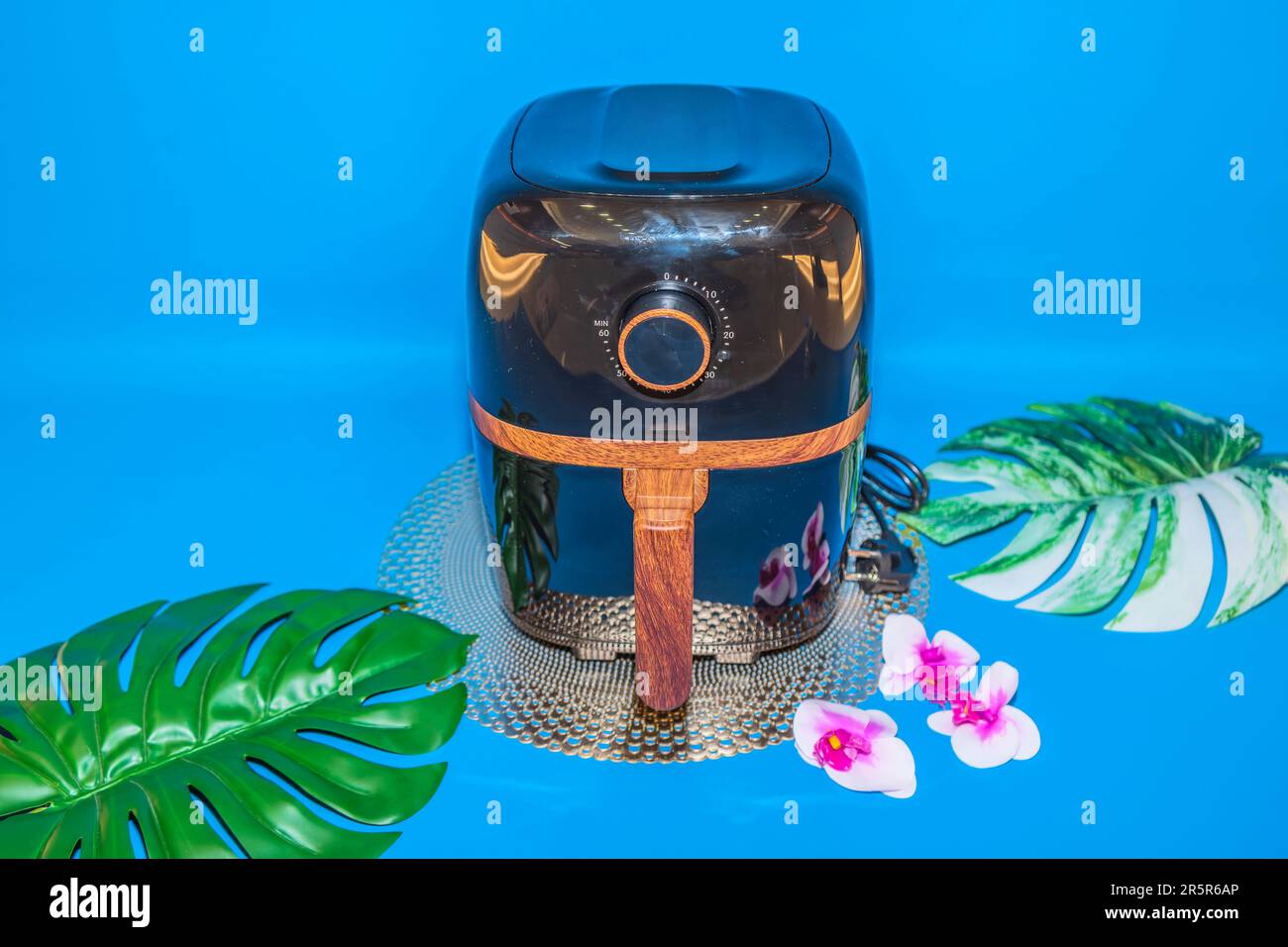 The Black Air Fryer with Wooden Handle Design offers a combination of