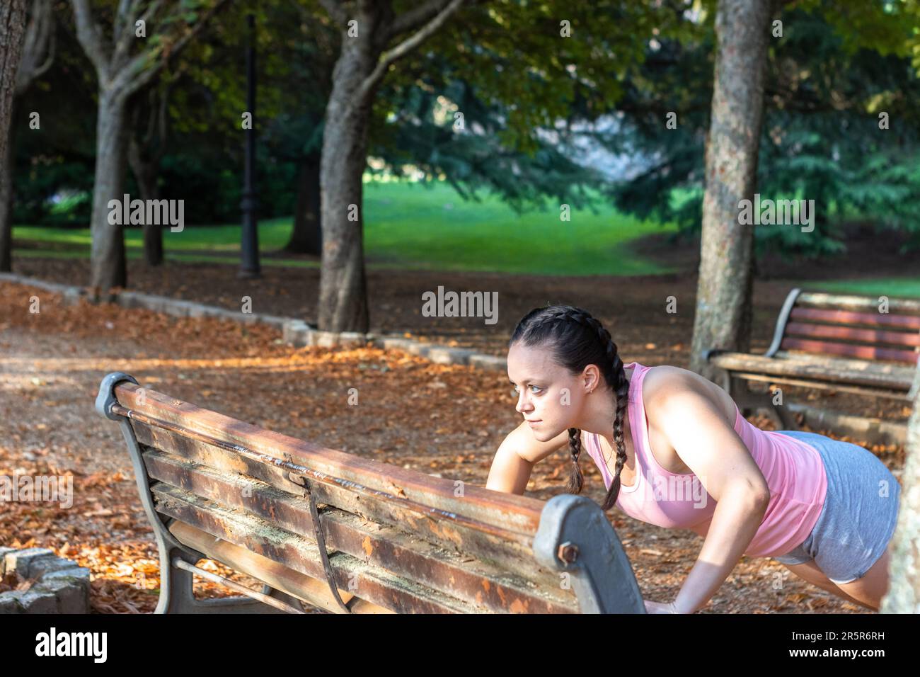 A mature woman exercising outdoors on a park bench Stock Photo - Alamy