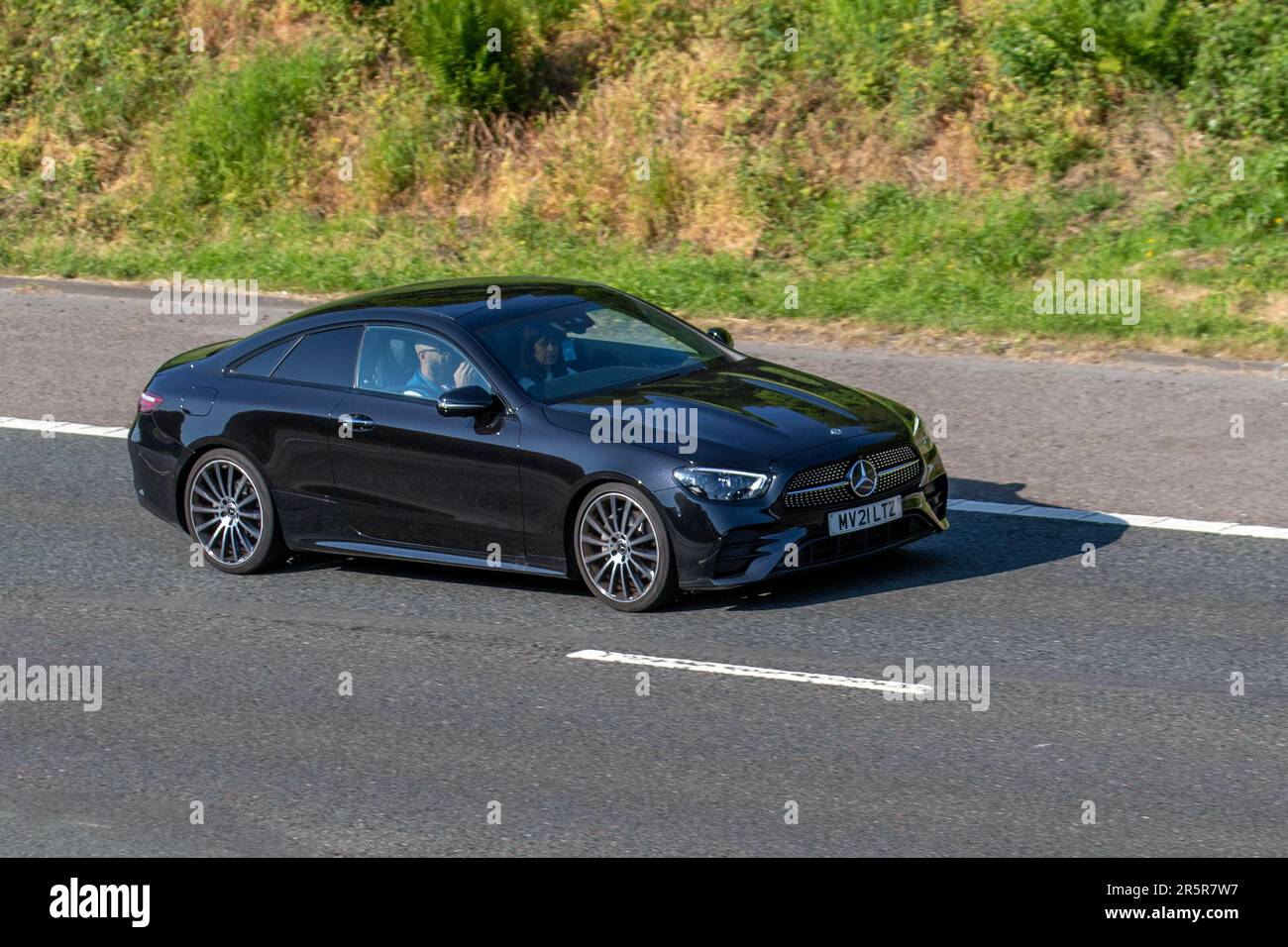 2021 Black Mercedes-Benz E 220 AMG LNE NGT ED PRM, + D A E220d 9G-Tronic Auto Start/Stop Car Coupe Diesel 1950 cc; travelling on the M61 motorway, UK Stock Photo