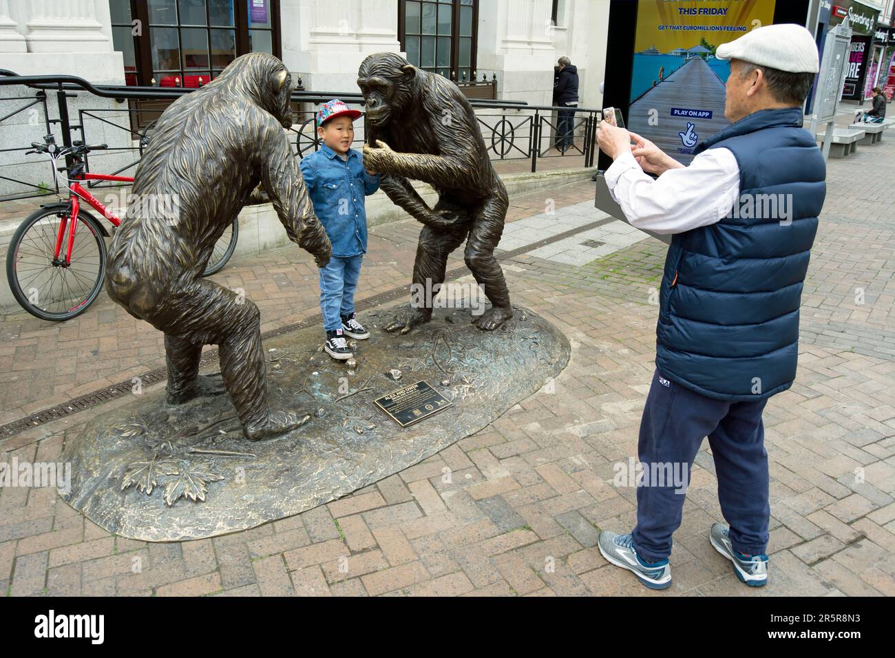 the bronze sculpture by gillie and marc, wild chimp conflict, encourages a family photo, in kingston upon thames, surrey, england Stock Photo