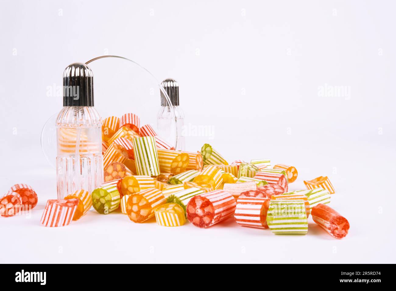 Spilled group of colorful sweets and cologne. Bowl of candies, many treats. Isolated white background, copy space.  Ramadan feast concept image. Stock Photo