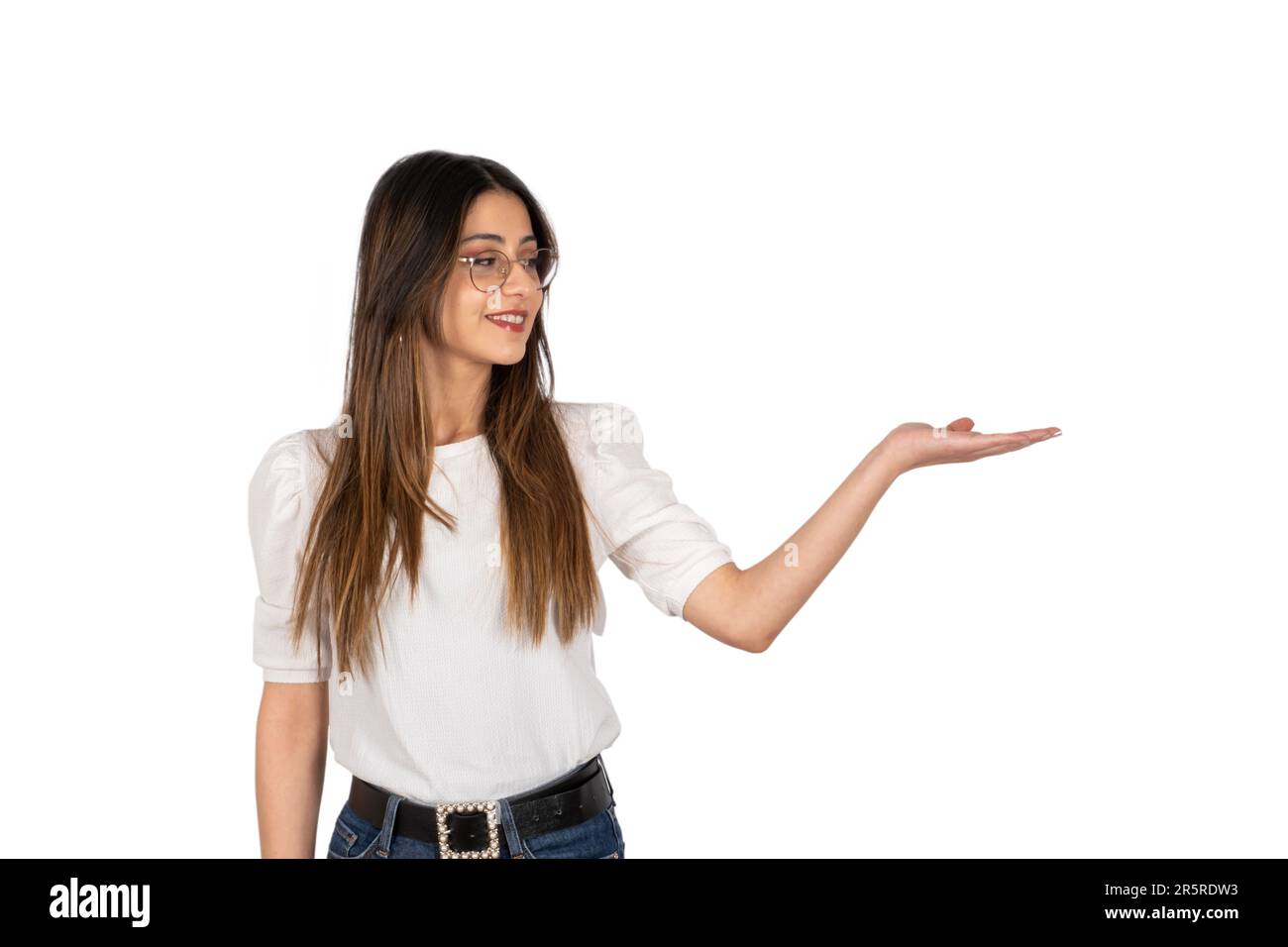 Young brunette  woman looking her open hand palm, holding imaginary product object. Advertising concept idea image, isolated copy space. Stock Photo
