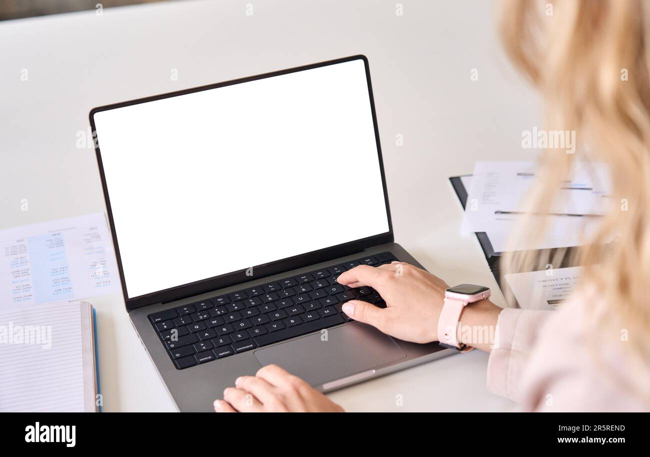 Business woman working on laptop using computer mock up screen. Over shoulder Stock Photo