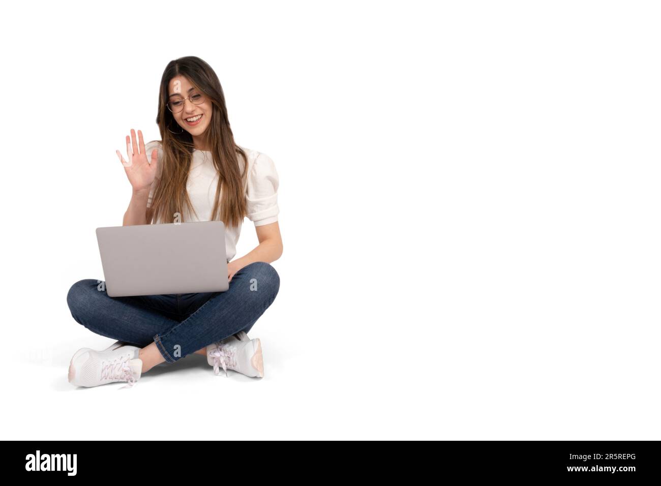 E-learning concept, caucasian 20s university student e-learning concept. Sitting on the ground, holding laptop wave hand. Distance education. Stock Photo