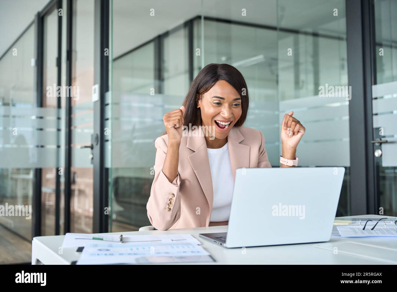 Excited young business woman looking at laptop celebrating financial ...