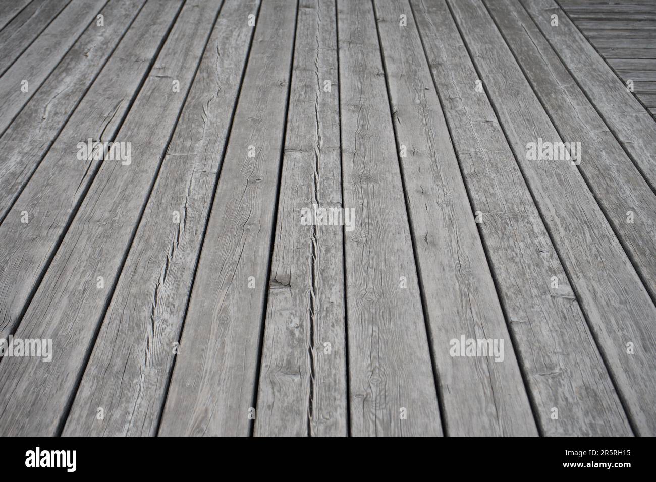 A flooring surface featuring a combination of grey wood boards and a non-wood material, creating an interesting visual contrast Stock Photo