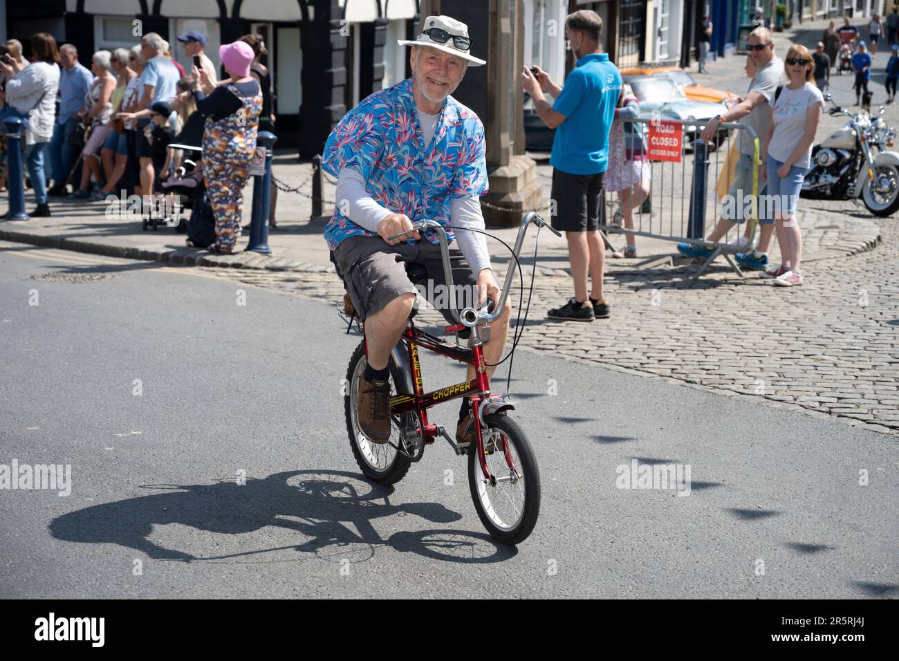 A man rides his childhood bike, a Raleigh Chopper from the 1960's, in the Veloretro vintage cycling event in Ulverston, Cumbria, UK. Stock Photo