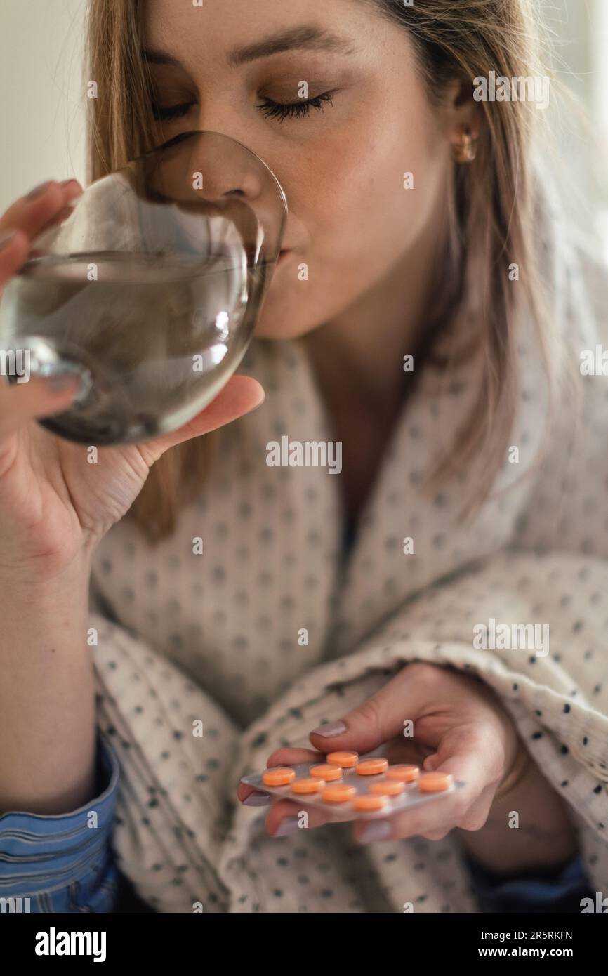 Close up of young woman taking pills. Stock Photo