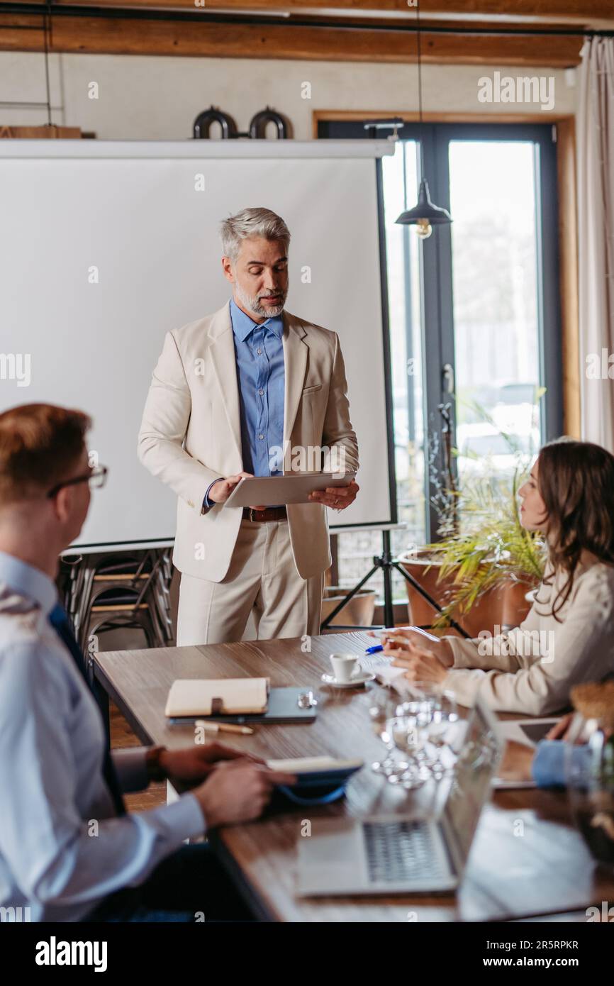 Mature businessman giving a presentation in a business meeting Stock ...
