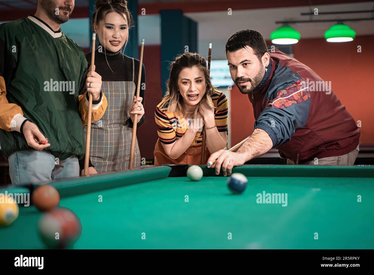 Billiards game. young friends playing pool together Stock Photo - Alamy