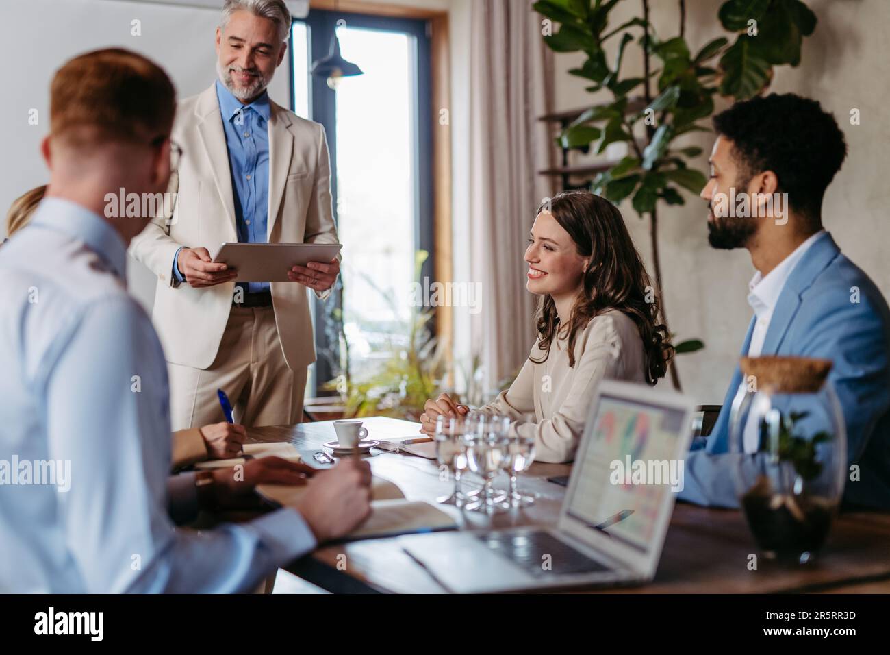 Mature businessman giving a presentation in a business meeting. Stock Photo