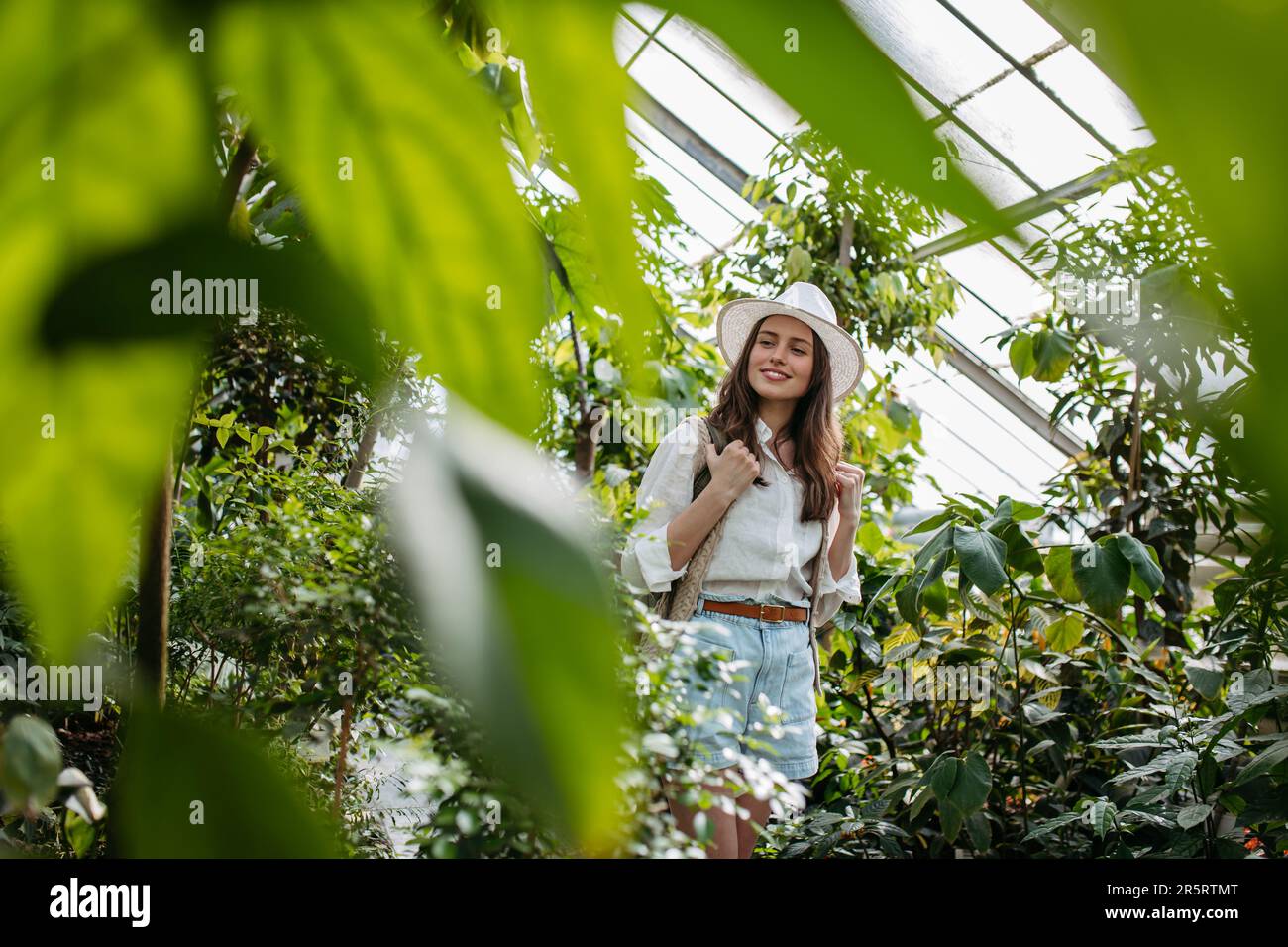 Portrait of young woman in botanical garden. Stock Photo