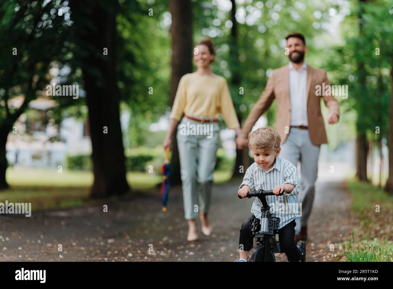 Young family with little son on walk after work. Stock Photo