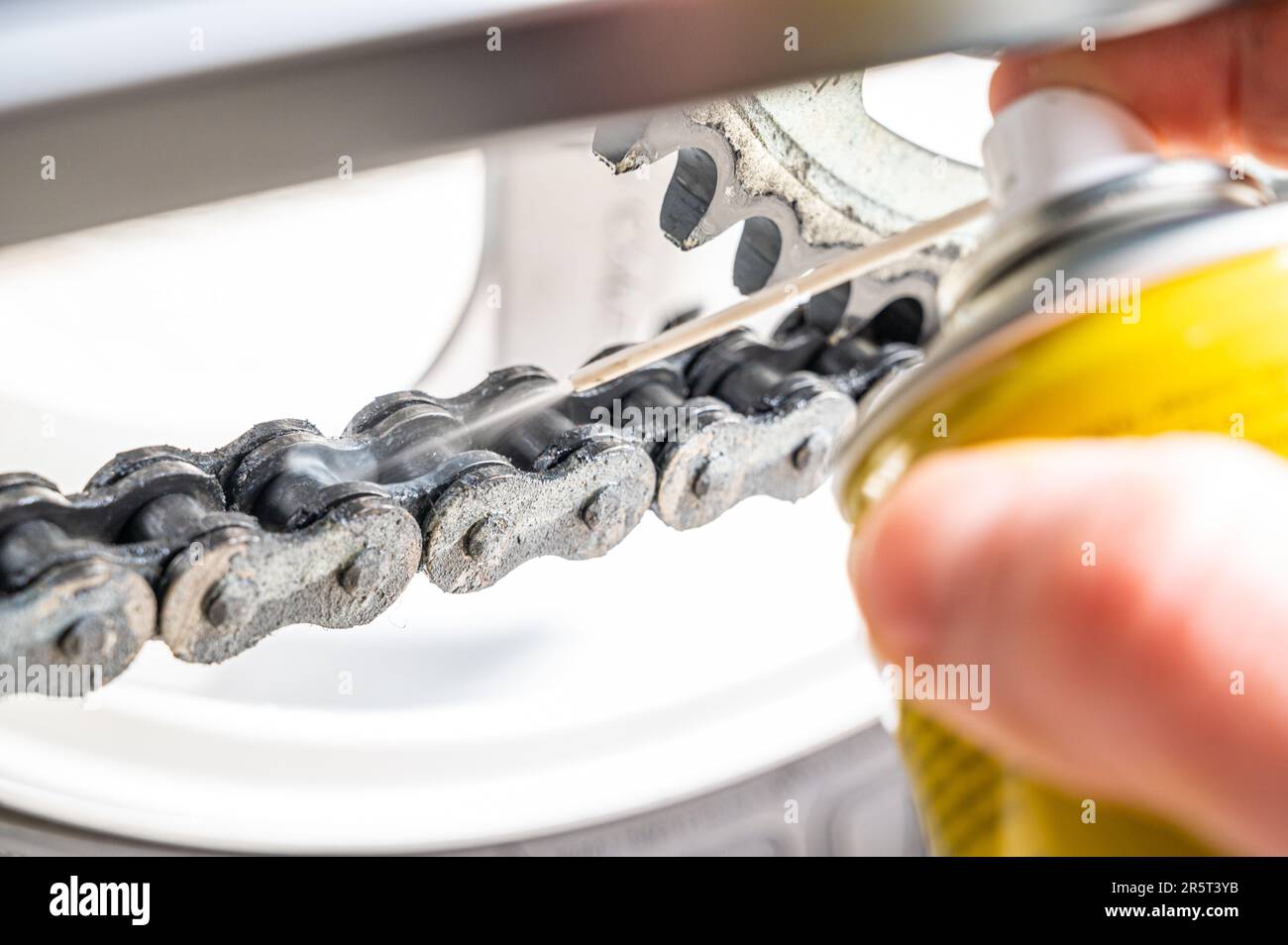 Motorcycle drive chain close up, and grease spray lubricant Stock Photo