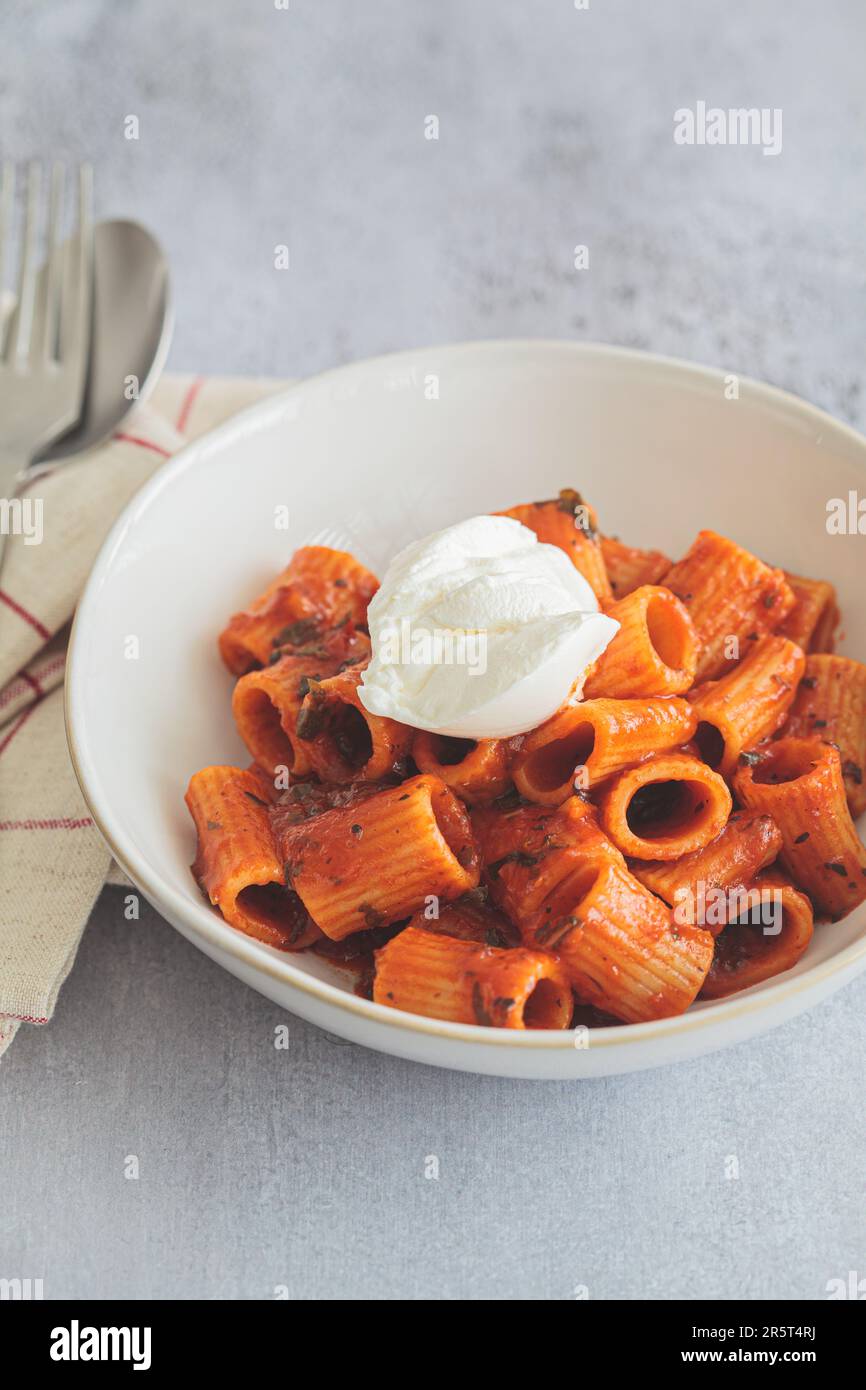 Vegetarian pasta with tomato sauce and cream cheese in a white bowl