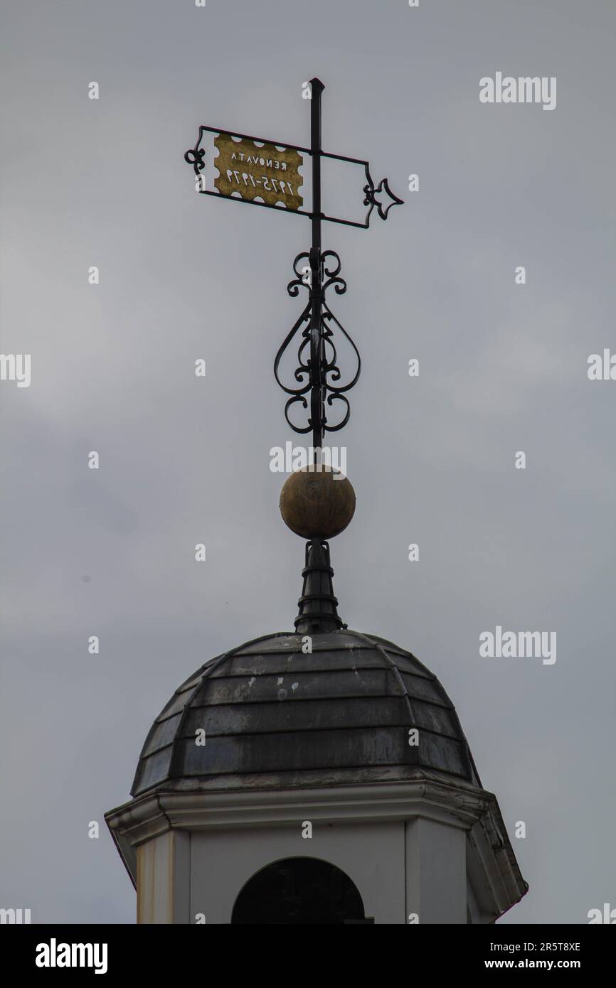 A detailed black and white weather vane adorning an old clock tower, perched atop a grand structure Stock Photo