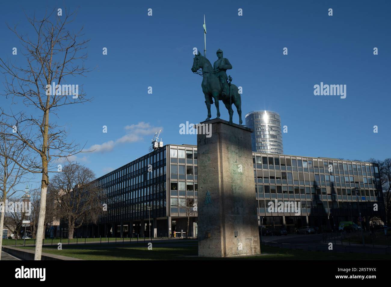 A black and white image of a majestic equestrian statue of a man atop a horse in front of a grand, imposing building Stock Photo