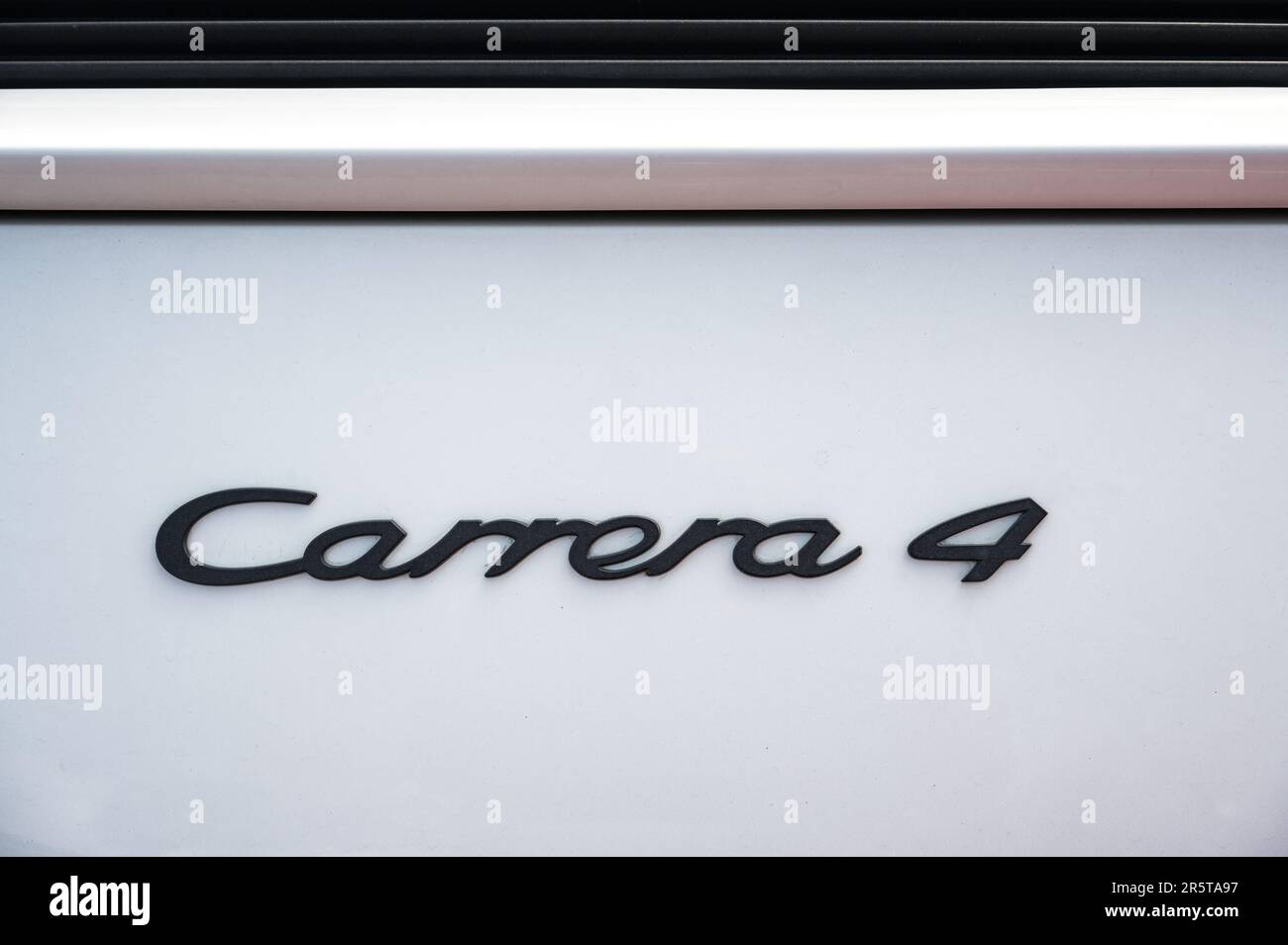 Detail of the Carrera 4 letters of a classic white Porsche 911 964 in the street Stock Photo