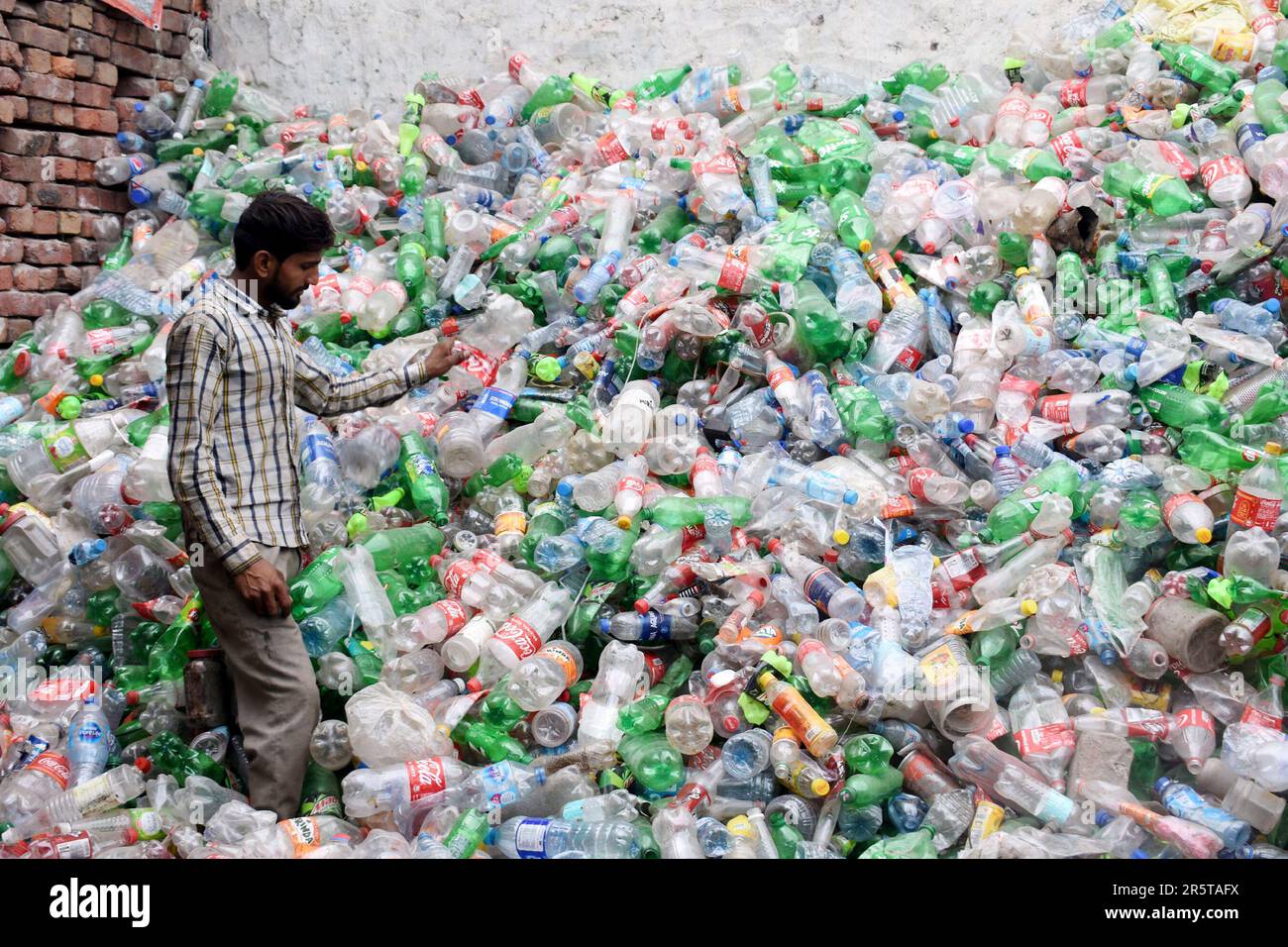 Lahore. 5th June, 2023. A worker checks recycled plastic bottles at a