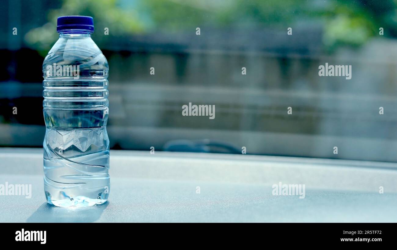 a bottle of mineral water on the dashboard of the car. Bottled water