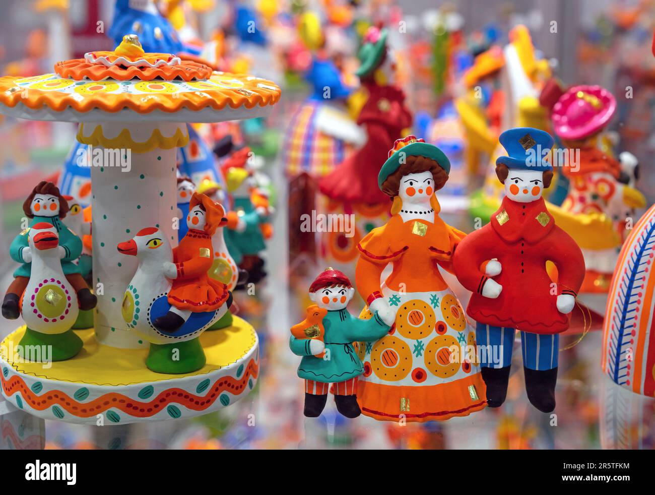 Clay figurines of people in bright clothes. Dymkovo toy. Stock Photo