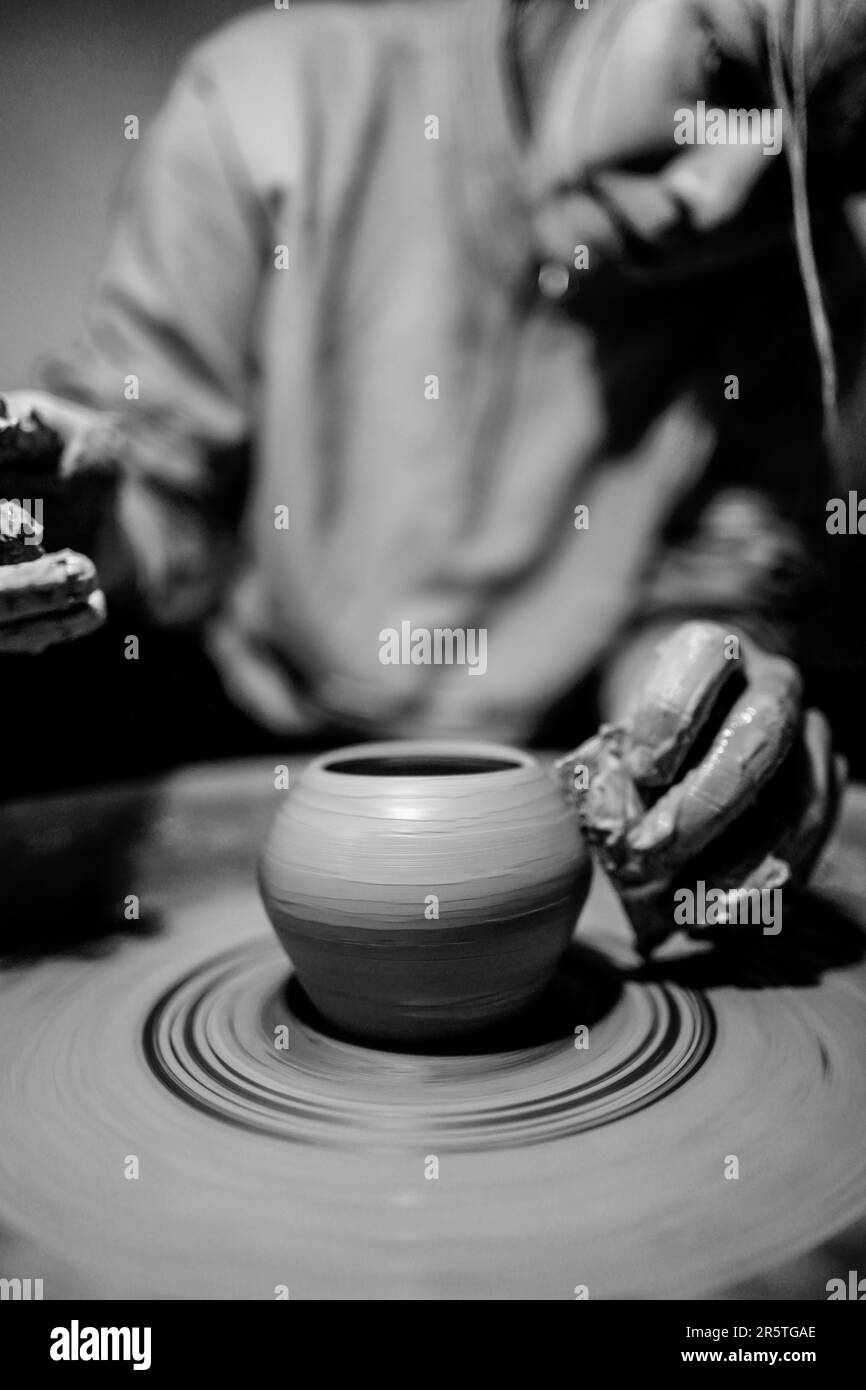 A striking black and white image of a man throwing a lump of clay onto