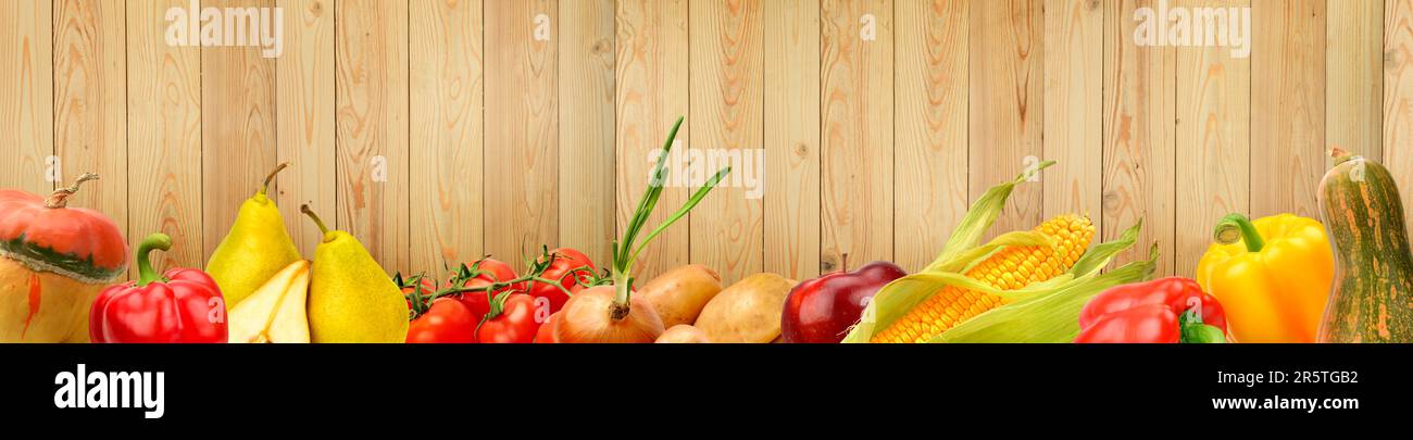 Wide panoramic photo ripe vegetables and fruits on background of wooden wall. Stock Photo
