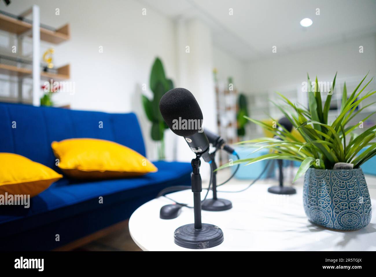 Simple studio room with blue chairs. Podcast media studio to broadcast audio. Audio settings for podcasting, microphone, speech, or interview. Stock Photo