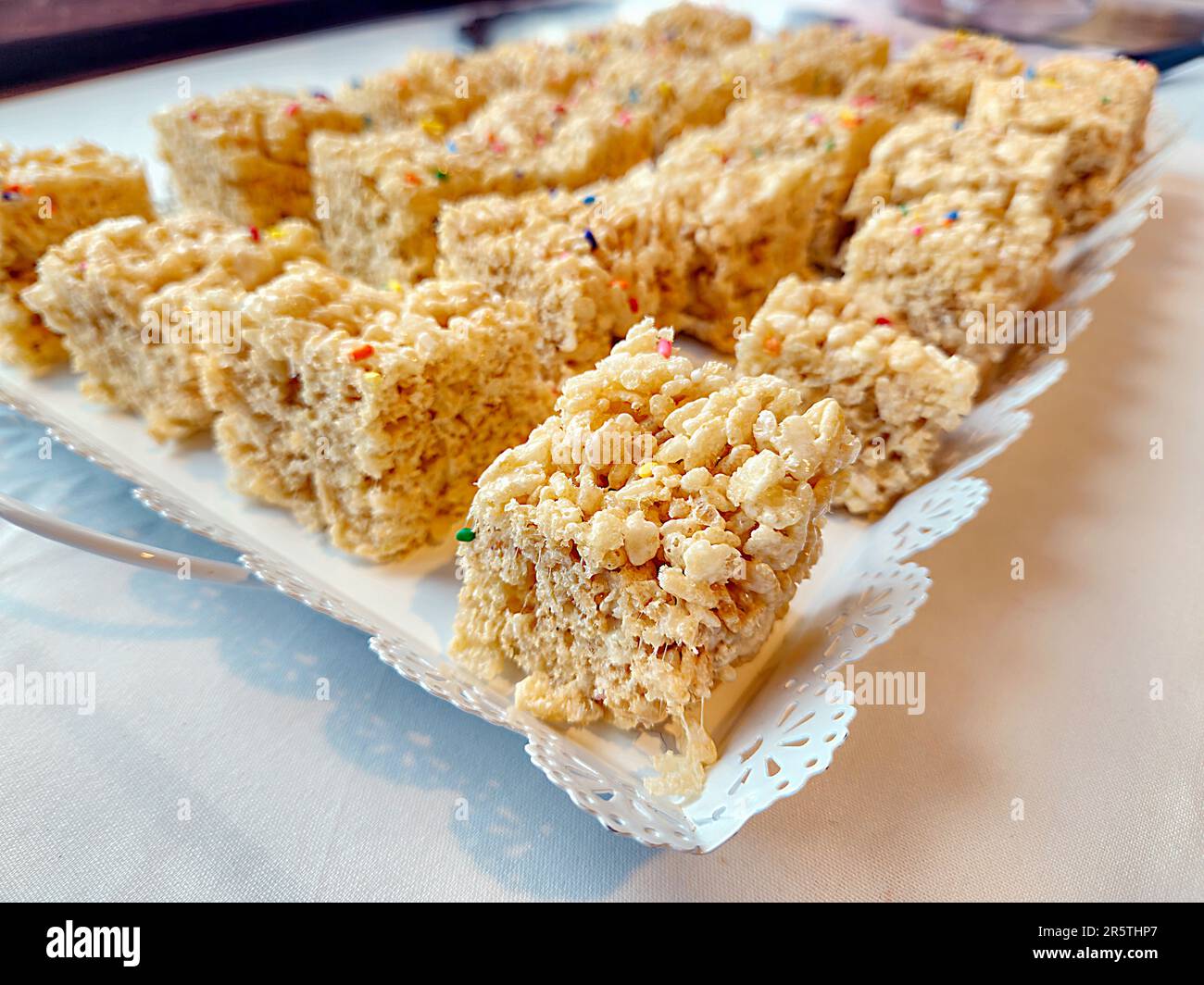 Closeup of rice crispy bars with rainbow sprinkles on a white plate Stock Photo