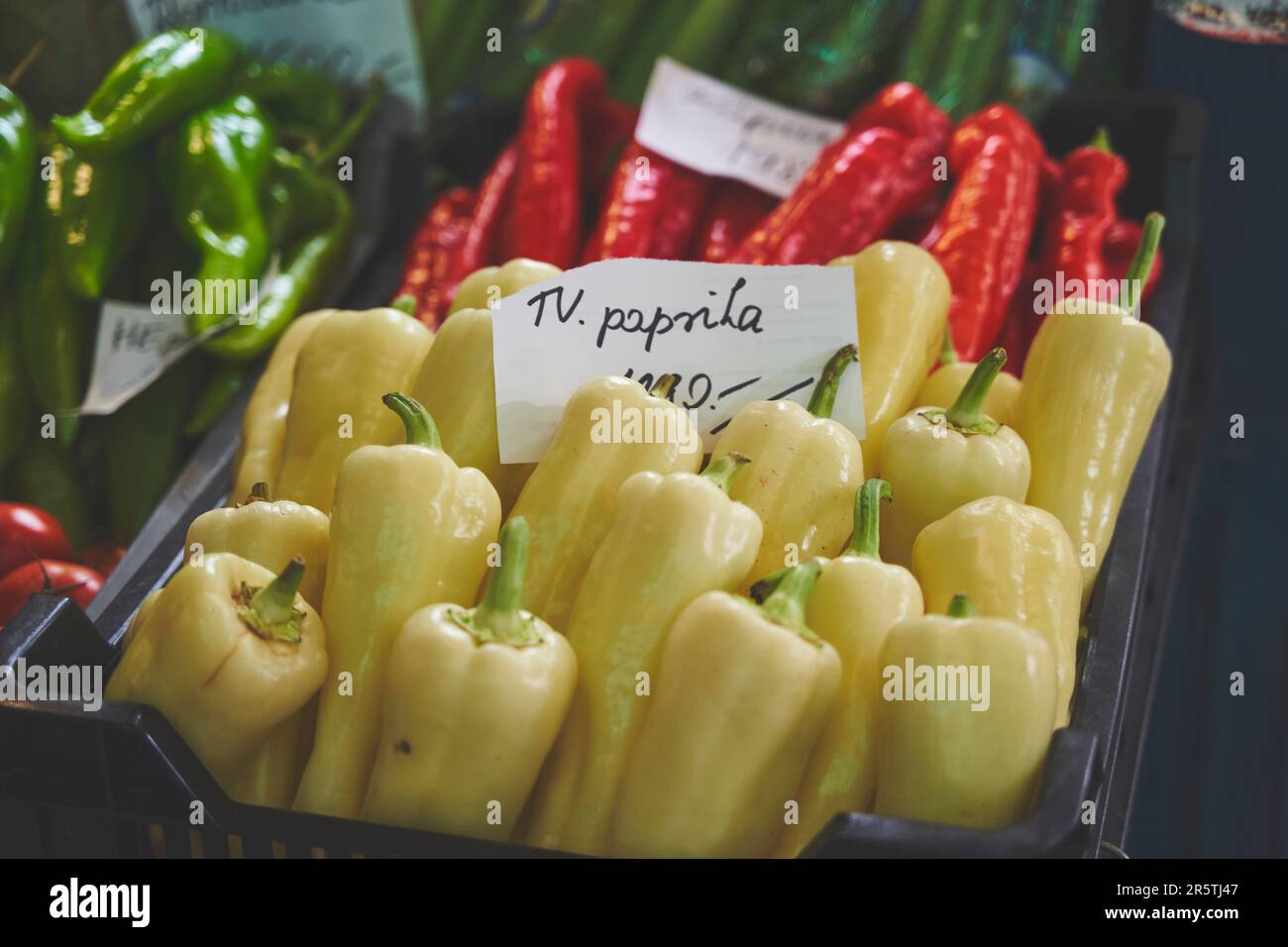 A variety of freshly picked peppers are available for purchase at a bustling market stall Stock Photo