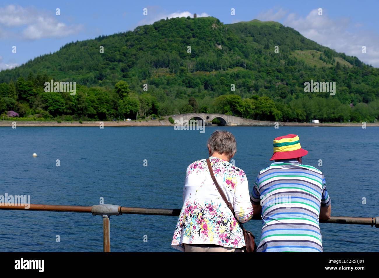 Inveraray, Scotland, UK. 5th June 2023.  Glorious warm and sunny weather continues on the west coast, people enjoying the outdoors in an attractive setting with the scenic villages along the coast. Looking over Loch Fyne to the humpback bridge on the A83.    Credit: Craig Brown/Alamy Live News Stock Photo