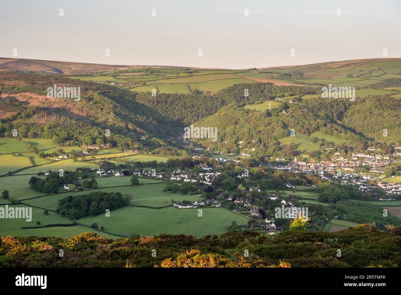 Morning sun falls on the hills of Exmoor above Porlock village on West Somerset. Stock Photo