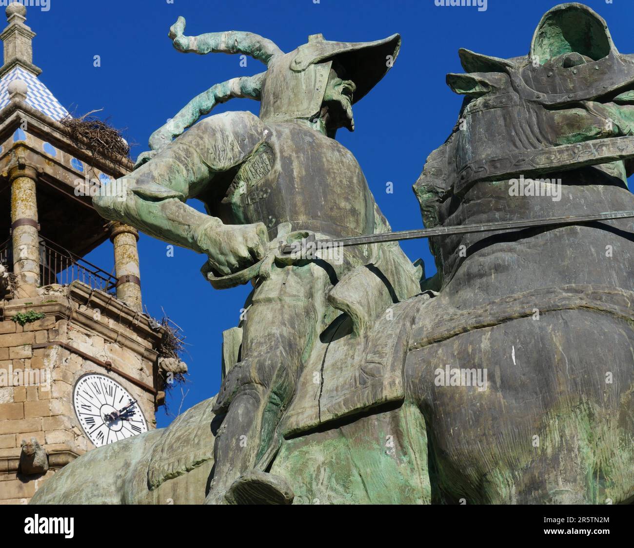 Detail of the equestrian statue of the conquistador Francisco Pizarro in the square of Trujillo with the bell tower of the church of San Martín Stock Photo