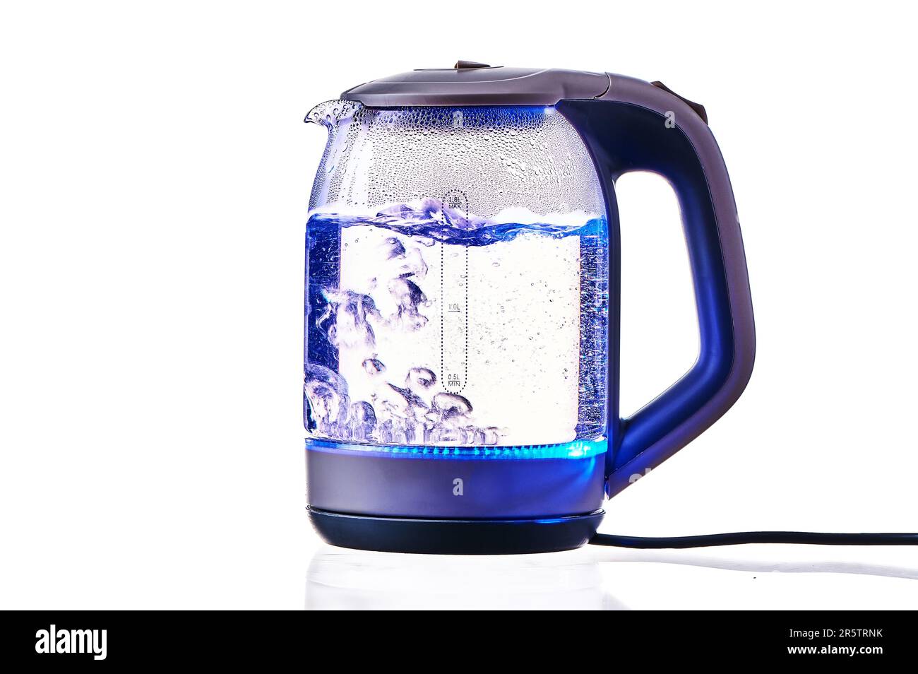 Glass electric kettle with boiling water on a white insulated