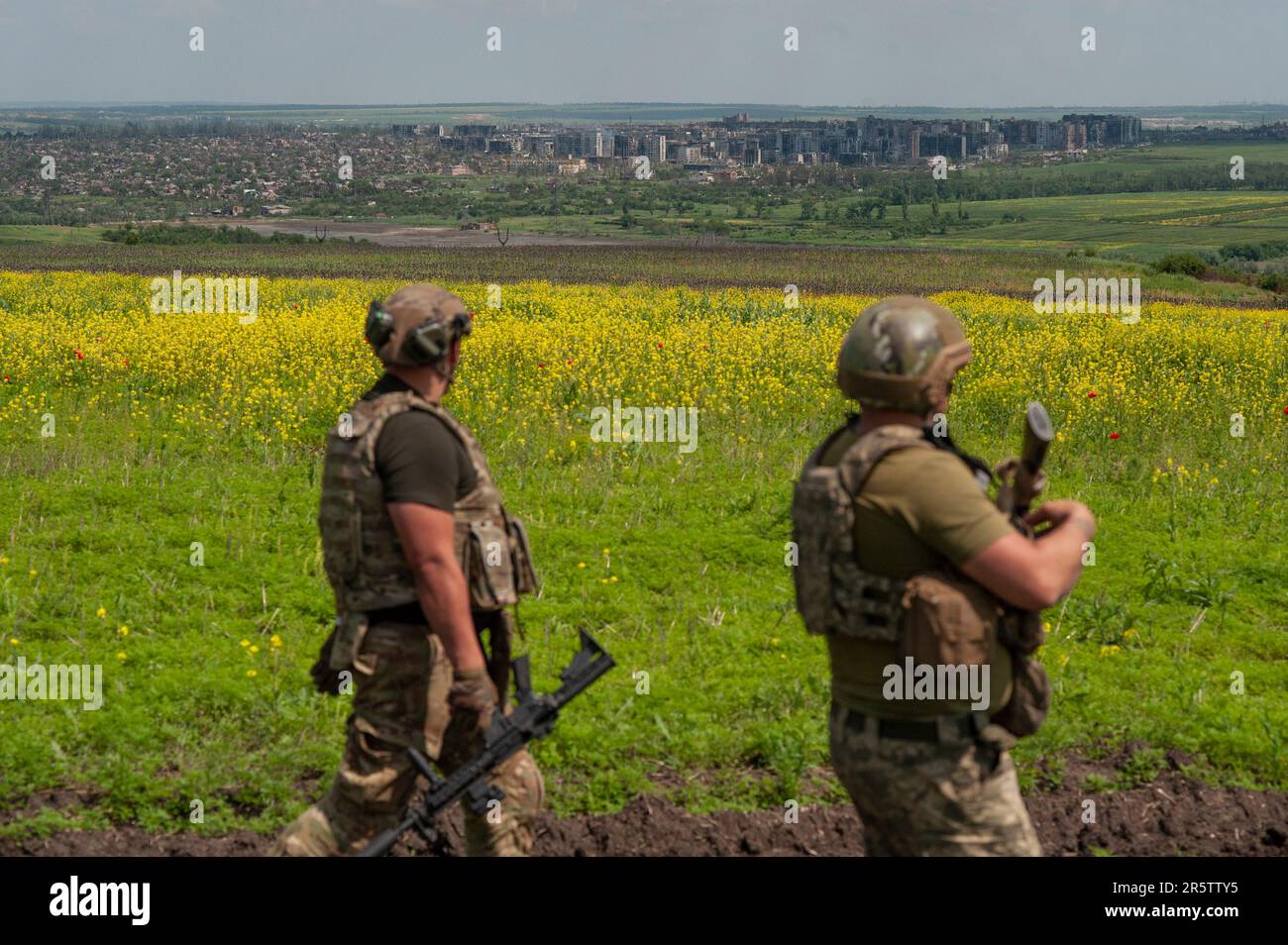 Ukrainian soldiers stand in their positions near Bakhmut, background ...