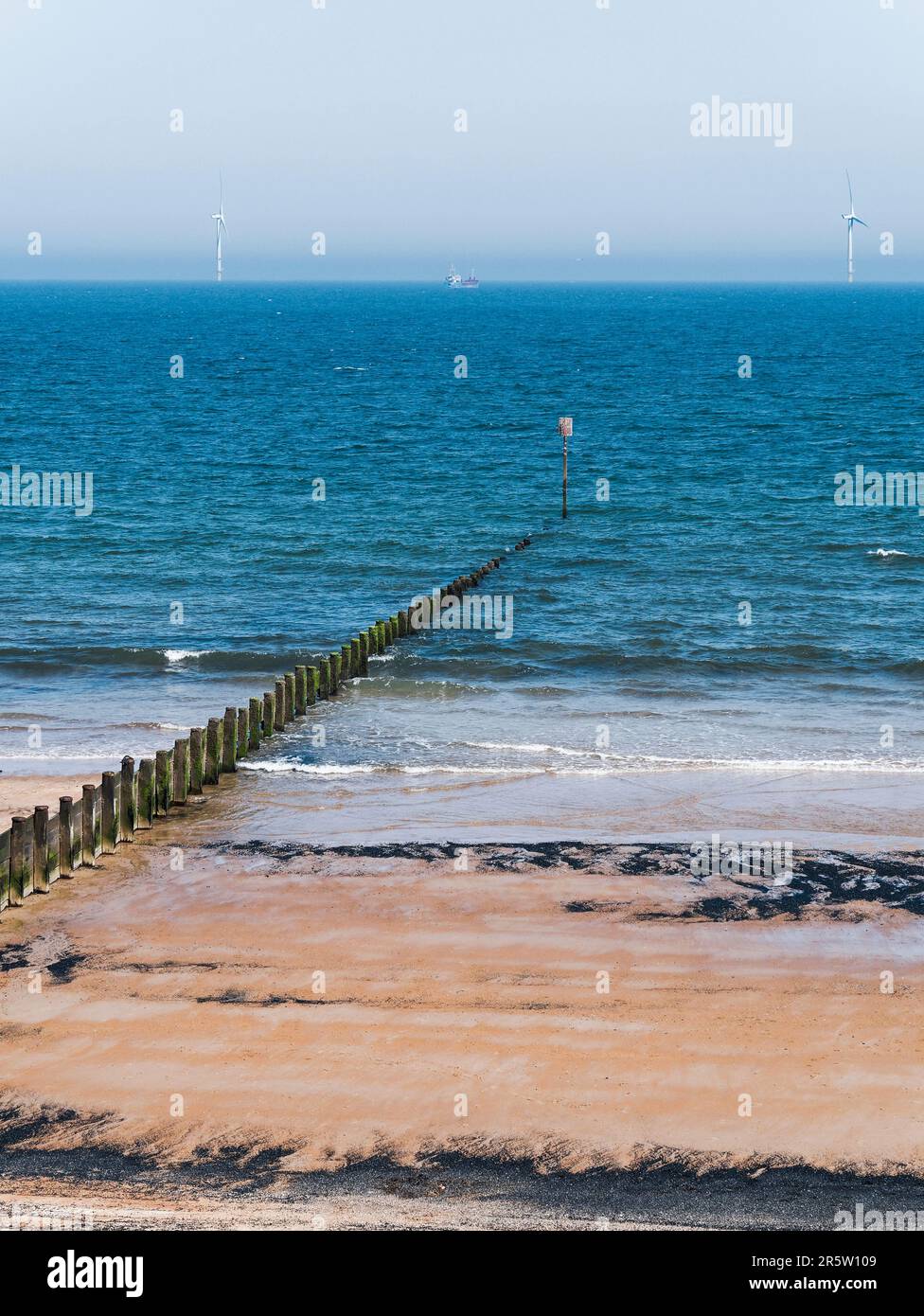 Cambois a tidal beach in Nort East england wit sea coal frm a mining heriage and wind farm in te distance. Stock Photo