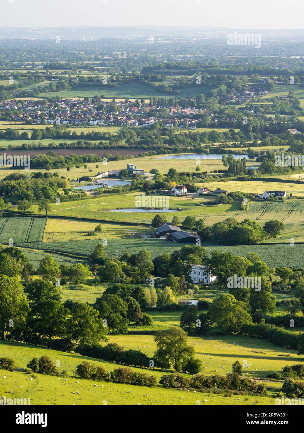 Fields and large houses, including the modernist Swinhay House, fill the landscape of rural Gloucestershire below the Cotswolds Edge at Wotton-under-E Stock Photo