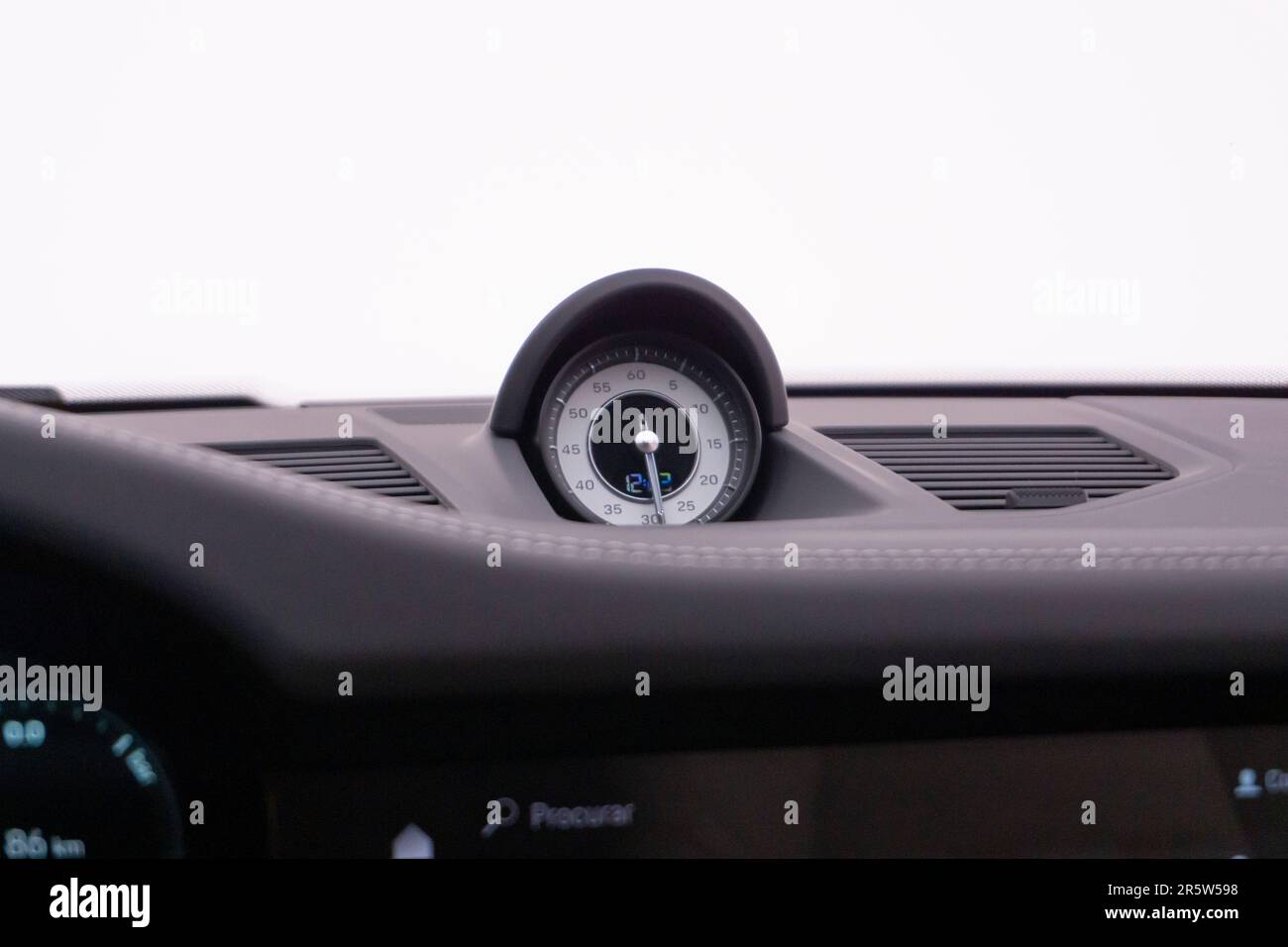 The dashboard panel of a car featuring the clock, speedometer, and