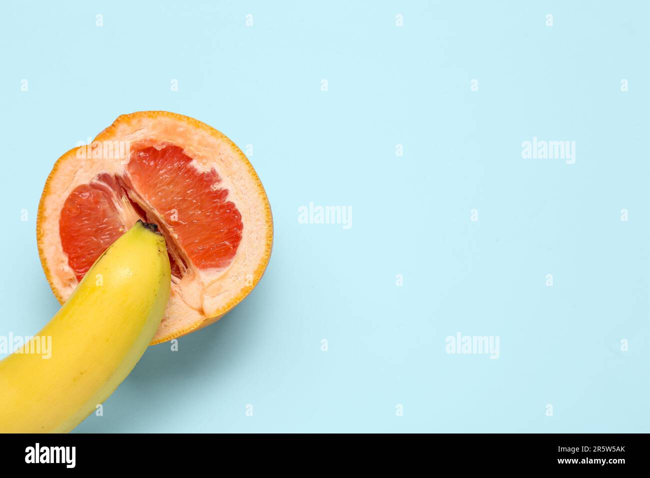 Banana with half of grapefruit on blue background, closeup. Sex concept  Stock Photo - Alamy