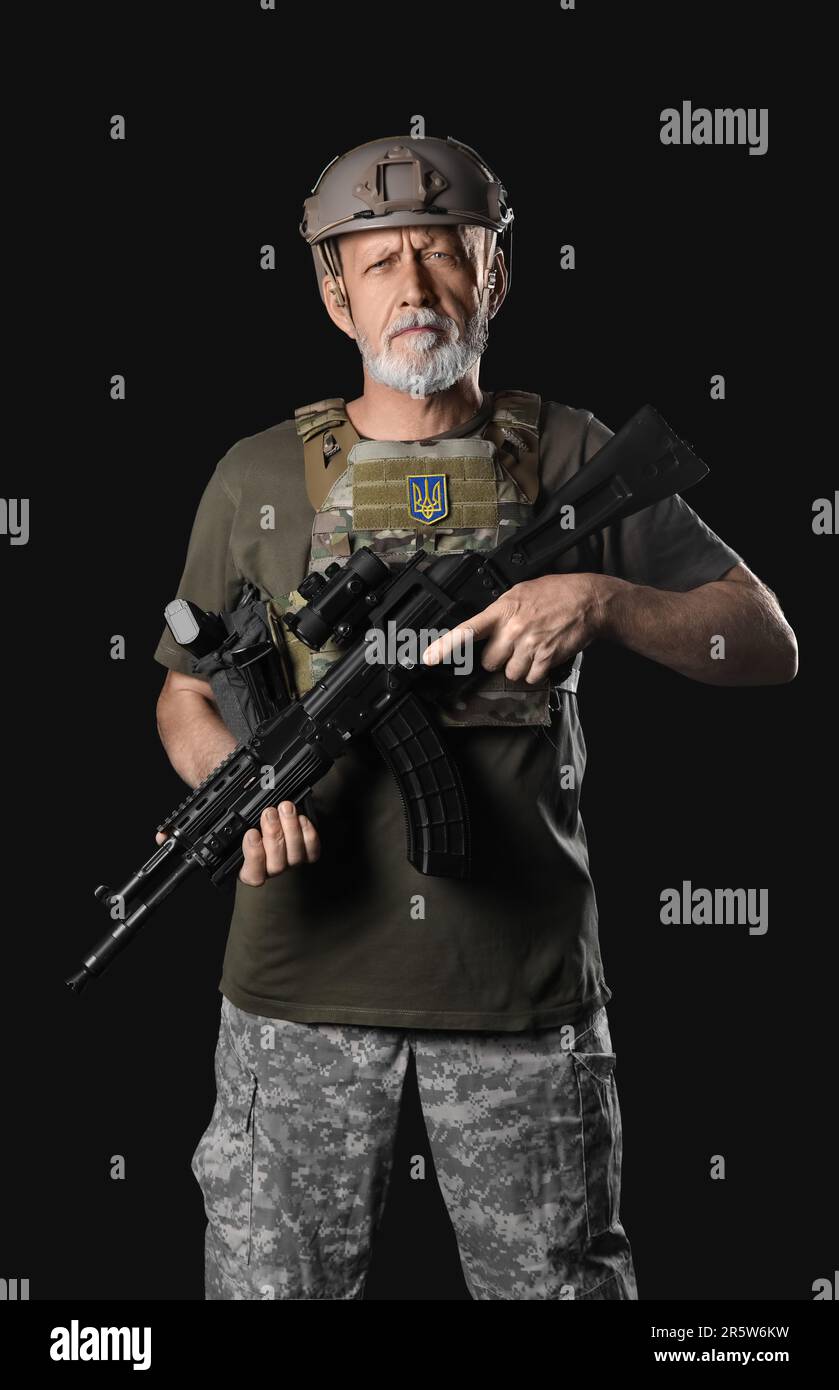 Ukrainian soldier with assault rifle on dark background Stock Photo - Alamy